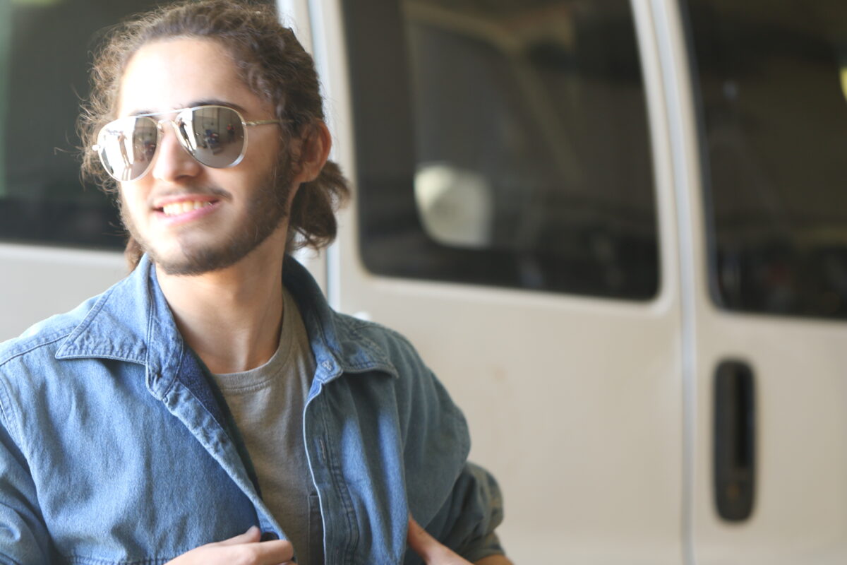 A boy smiles near a van door.